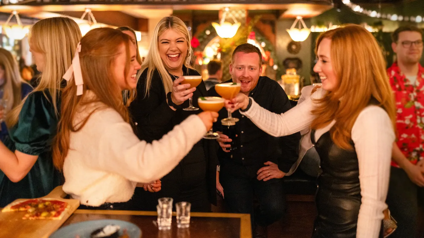 groups of friends toasting a cocktail and smiling