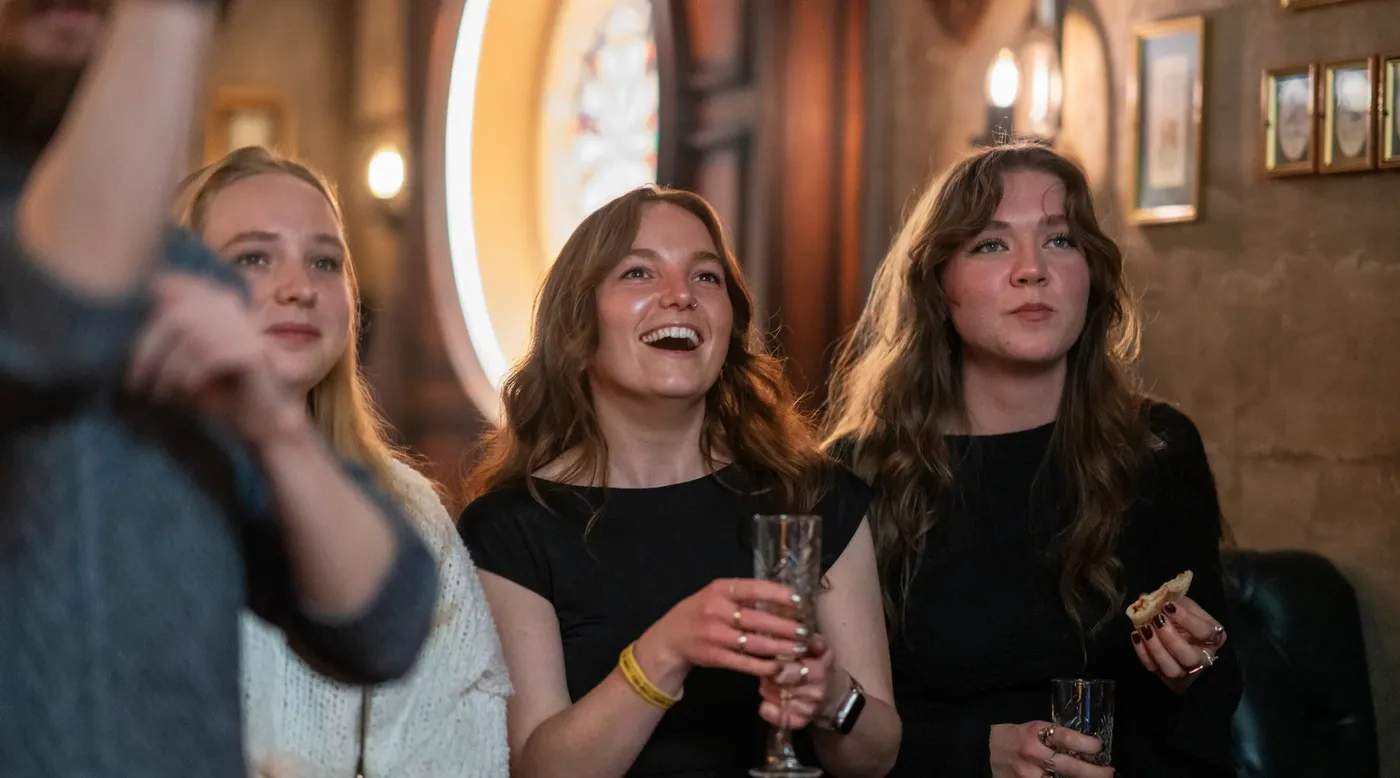 A group of people celebrating at an oche in Flight Club